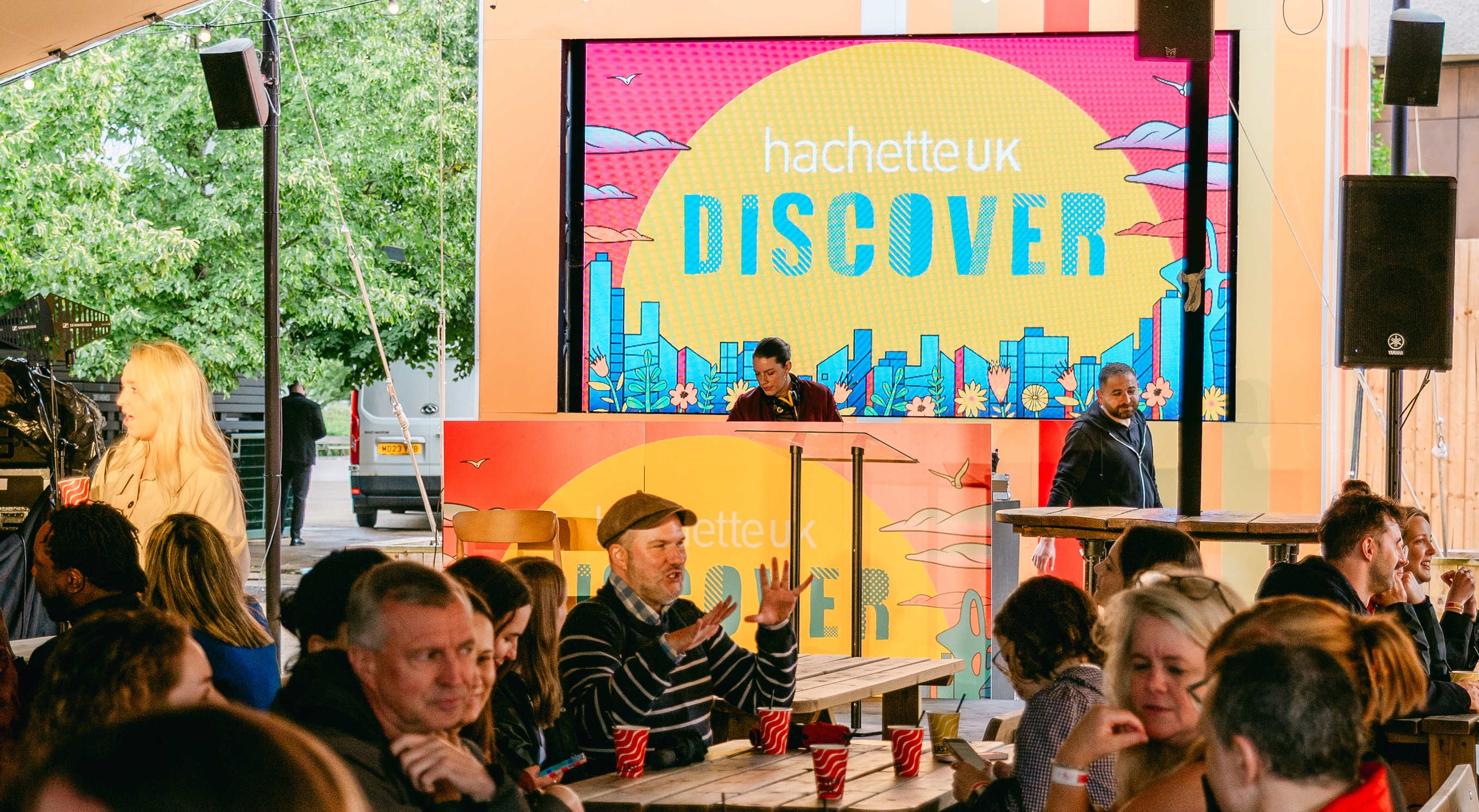 Image of the word discover on a screen with people sat near the screen